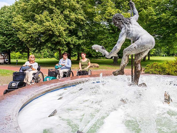 Urlaubsgäste im Rollstuhl am Neptunbrunnen